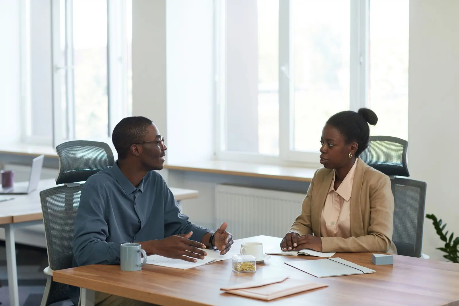 Two colleagues at a meeting table confirming a booking